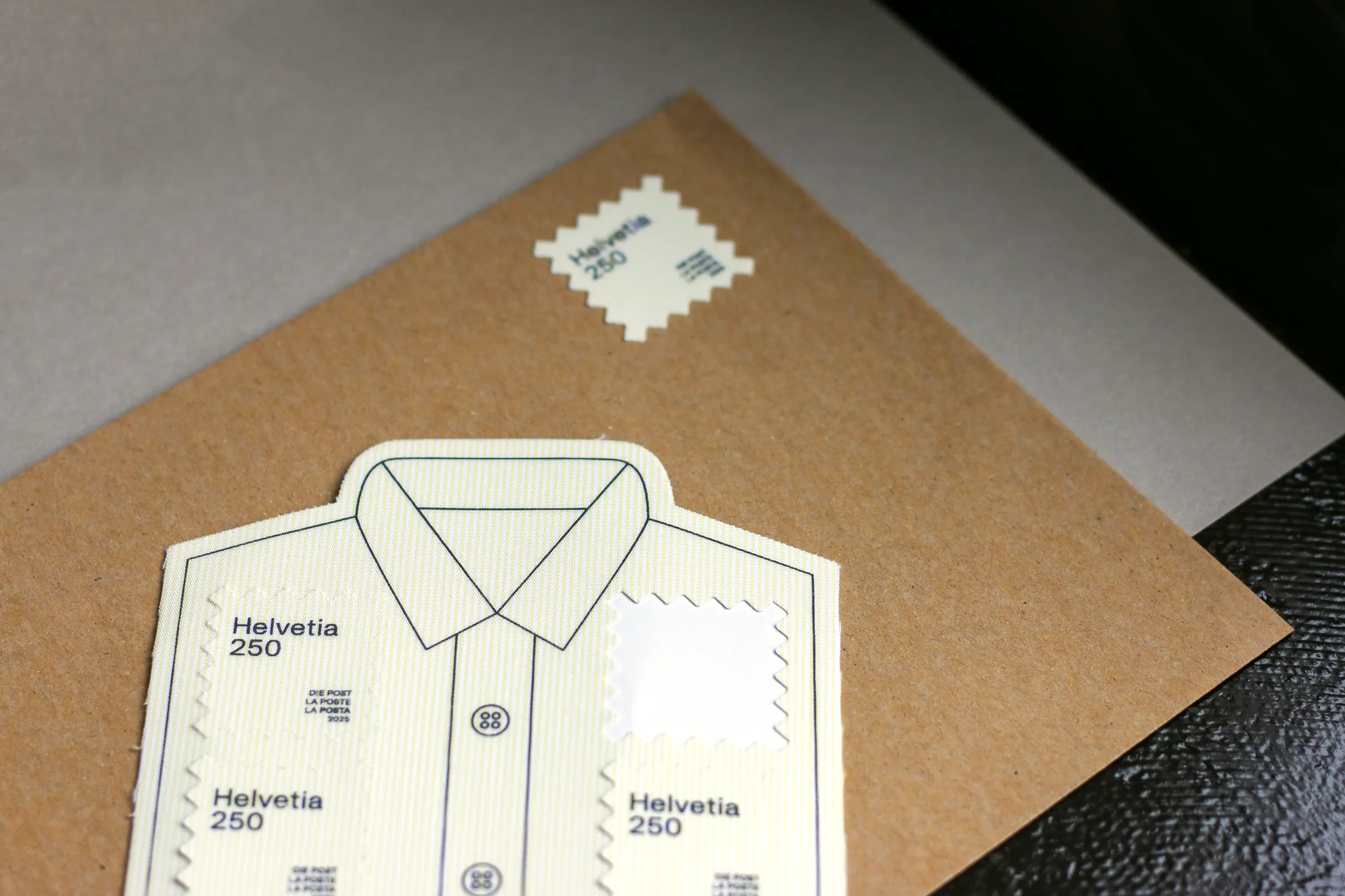 Briefmarkenbogen in Hemdform und ein braunes Couvert mit Briefmarke Upcycling-Briefmarke
