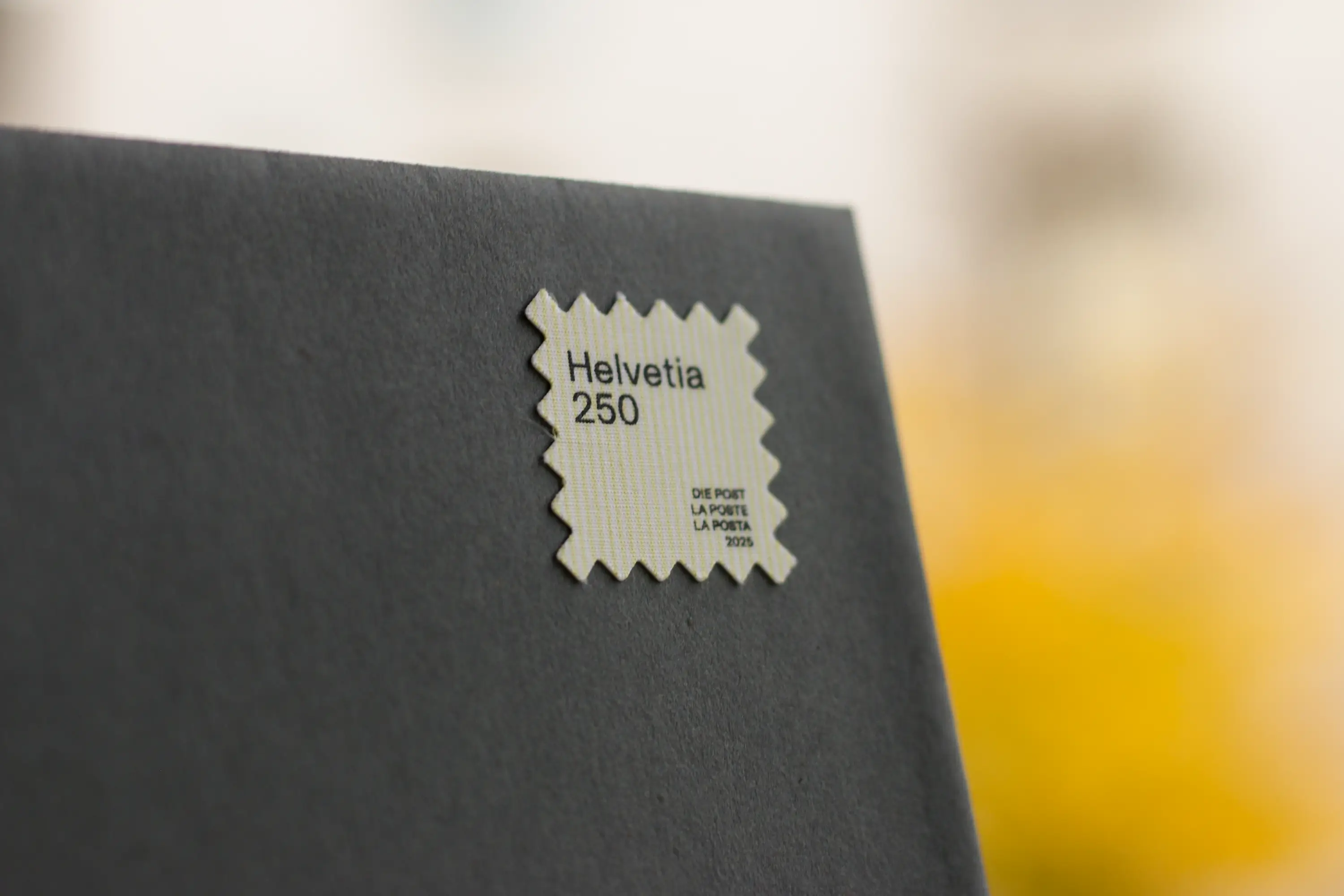 Briefmarke Upcycling auf einem dunkelgrauen Couvert mit verschwommenen Hintergrund